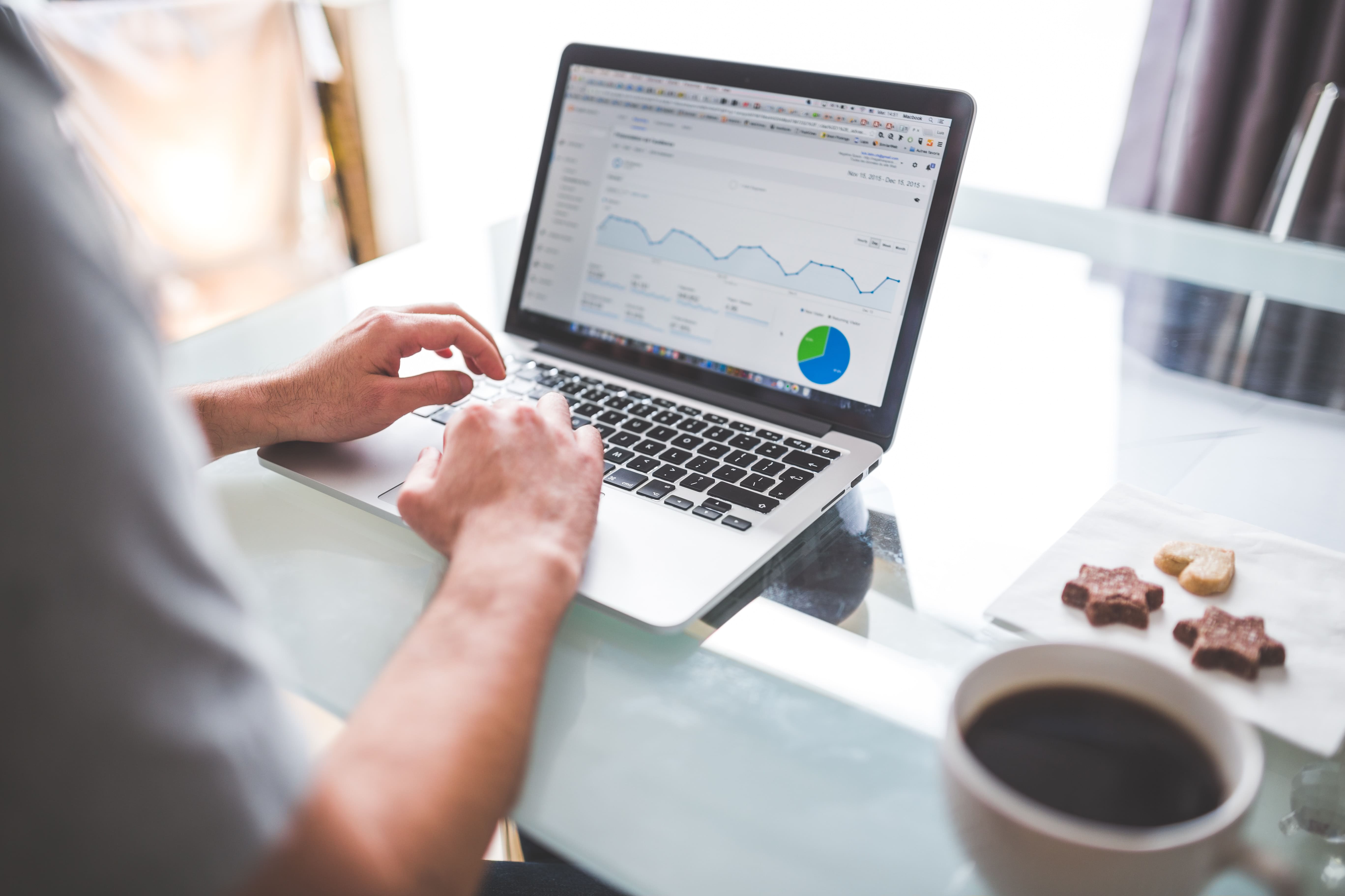 An individual using a computer at a desk viewing Google Analytics